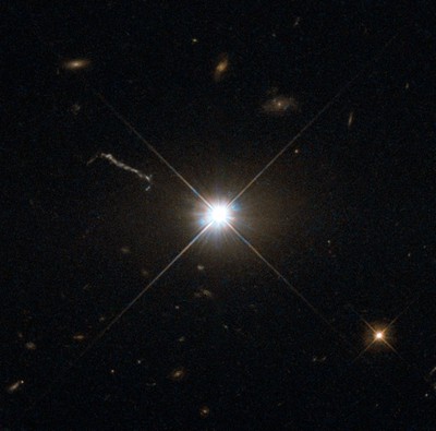 Optical image of the quasar **3C273**, obtained with the **Hubble Space Telescope**. The quasar resides in a giant elliptical galaxy in the constellation of **Virgo** at a distance of about *2.5 billion light-years*. It was the *first* quasar ever to be identified. Image via **ESA**/**Hubble**/**NASA**/**MPE**.