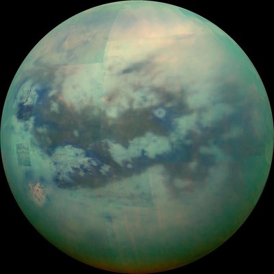 This composite image shows an infrared view of Saturn's moon, **Titan**, from **Cassini**, acquired during the mission's "T-114" flyby on November 13, 2015. At **visible** avelengths, this view would show only Titan's hazy atmosphere, but **near-infrared** wavelengths allow Cassini's vision to penetrate Titan’s haze and reveal the moon's surface. The view features the parallel, dark, dune-filled regions named **Fensal** (to the **north**) and **Aztlan** (to the **south**), which form the shape of a sideways letter **H**. Image Credit: **NASA**/**JPL**/**University of Arizona**/**University of Idaho**.